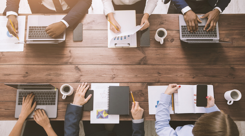 Corporate team working at office, with gadgets and documents